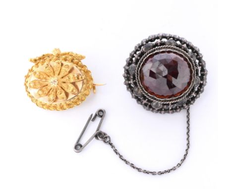 Twee broches, ca. 1900. Eén in 14 kt. goud en gedecoreerd met spinnetjes (missen enkele) de ander in zilver en bezet met een 