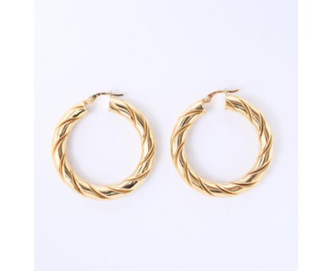 18 kt. Gouden oorringen, met een getwiste buis.  bruto 8,0 gr., diam. 34 mm, b. 5 mm [2] 18 k. Gold earrings, with a twisted 