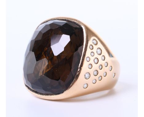 14 kt. Roodgouden ring. De bovenzijde bezet met een kussenvormige gefacetteerde rookkwarts van 23 x 23 mm. De zijkanten asymm