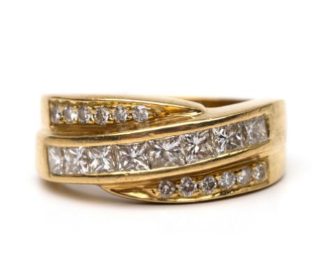 18 kt. Gouden band ring. De bovenzijde met een diagonale baan bezet met princess geslepen diamant met deel aan de boven- en o