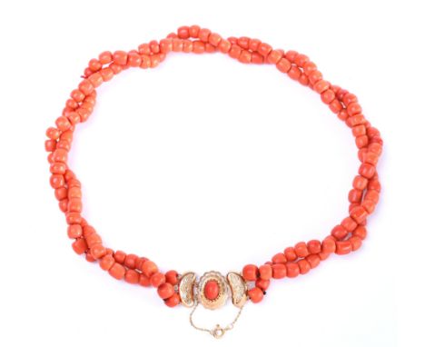 Collier van twee rijen bloedkoraal. De kralen tonvomig, diameter 7 - 8 mm. Aan een 14 kt. gouden sluiting bezet met een caboc