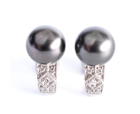 18 kt. Witgouden oorstekers, bezet met een Tahitiparel (diam 9 mm) en kleine briljant geslepen diamant bruto 5,3 gr., h. 15.4