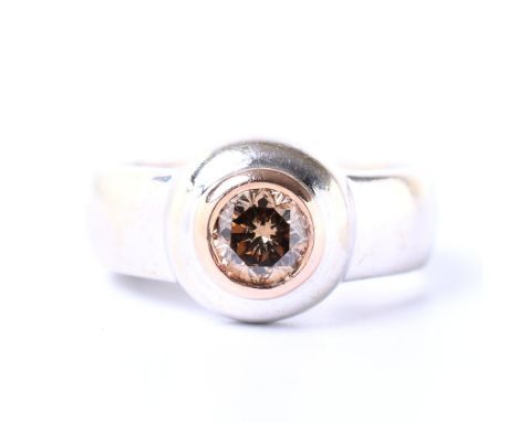 14 kt. Witgouden solitair ring, bezet met een bruine briljant geslepen diamant van ca. 0.50 ct.  in een roodgouden bezel zett