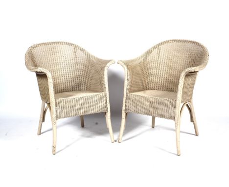 A pair of vintage Lloyd Loom 'Lusty' armchairs. Each painted in off-whitte pale-grey, with outswept arms and feet, each label