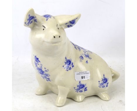 An early 20th century ironstone ceramic pig ornament. With white and blue floral transfer decoration, L24cm. 