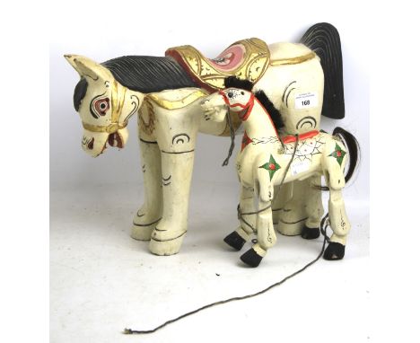 Two Far Eastern carved and painted wooden horses. One made as a puppet with jointed legs. Max. 27cm high