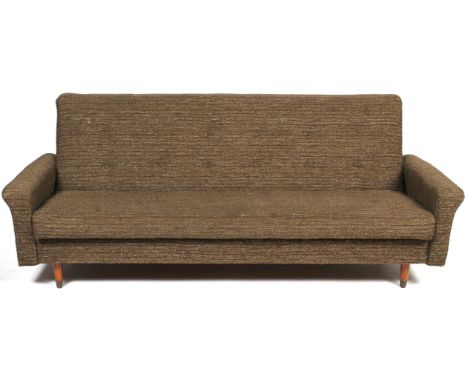 A 1960s three-seater button back sofa bed in the Danish style. Upholstered in mottled textured brown fabric, on tapering wood
