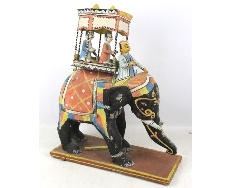 A vintage Indian carved and painted elephant with howdah model. 49cm high
