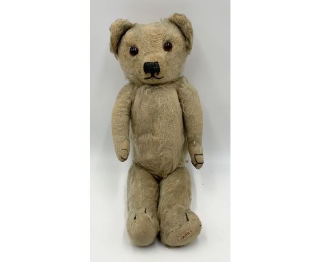 A vintage Merrythought teddy bear with glass eyes, stitched nose and canvas pads. Merrythought button to back.