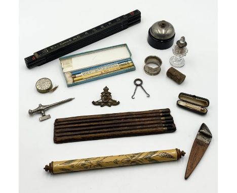 An interesting collection of items including vintage measuring stick, silver collared scent bottle and napkin ring etc.