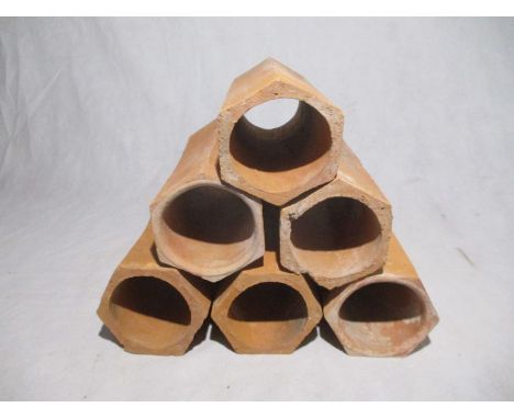 A set of six hexagonal terracotta pipes for wine storage - length 31cm