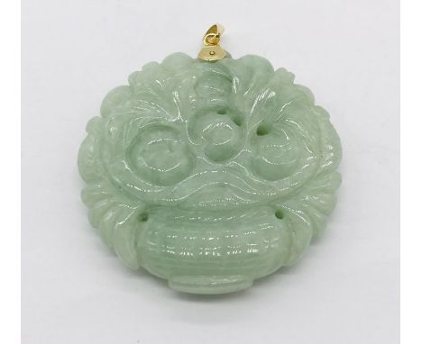 A carved jade pendant with 14ct gold mount