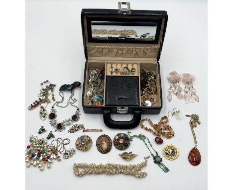 A collection of vintage costume jewellery in travel case including a number of brooches, rings and some silver