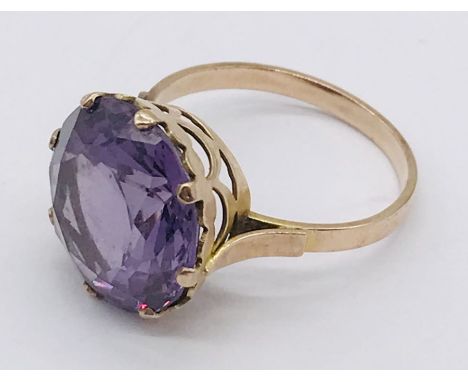 An 18ct gold ring set with large central amethyst