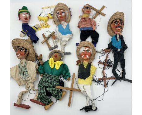 A collection of various vintage string puppets including Mexican characters, sailor, Pluto etc.