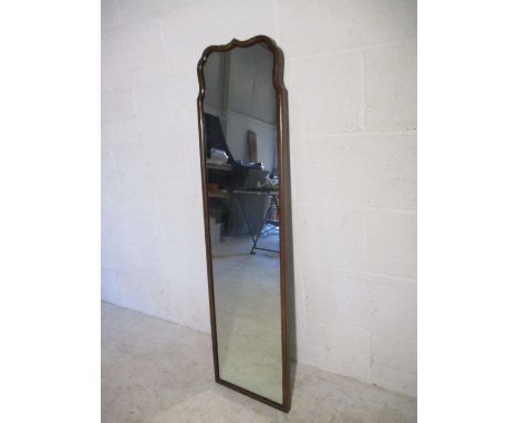 A vintage mahogany full length mirror with shaped top.