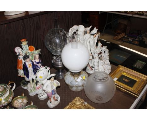 A silver plated oil lamp with clear glass shade; a mottled glass oil lamp with opaque glass shade and one other shade