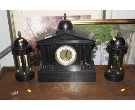 A late Victorian black slate mantel clock and garnitures 