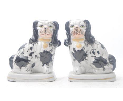A pair of 19th century Victorian Staffordshire ceramic mantlepiece dogs / spaniels. The pair each in black and white, with ha