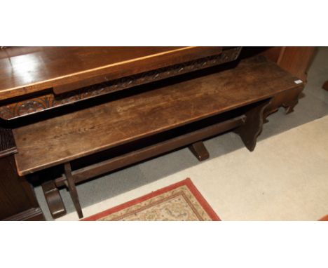 An oak bench, on shaped slab end supports and through tenon stretcher rail, 54" long