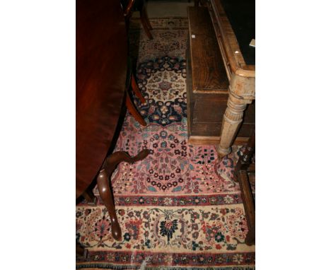 A Persian design carpet decorated central blue and ivory medallion on a pink ground with three border stripes, 144" x 116" ap