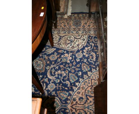 A Persian design carpet decorated central pink medallion on a blue floral ground, 12' x 9' approx (wearing)