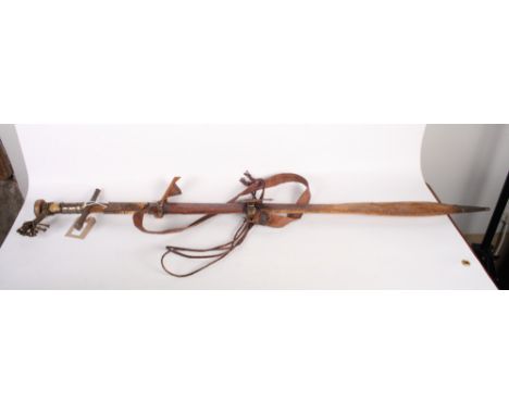 A North African sword with fullered steel blade, horn and white metal mounted grip, decorated leather scabbard, 41" long, bla