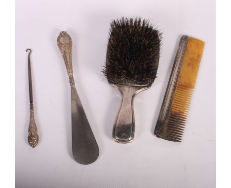 A repousse silver backed hair brush, a sterling silver hairbrush, a clothes brush, a buttonhook, a shoe horn and a comb