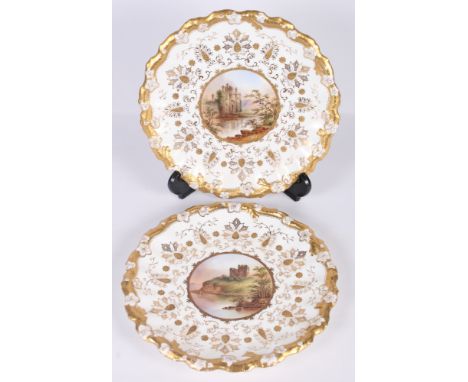 A pair of Coalport wall plates with gilt decorated borders and edges, centres painted named views of Benson and Caerlaverock 