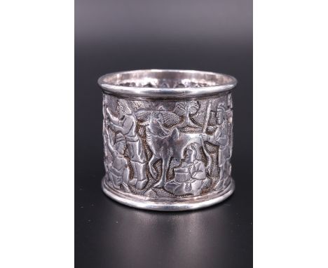 An early 20th Century Indian white metal napkin ring, decorated with a chased continuous hunting scene, (tested as silver), 4