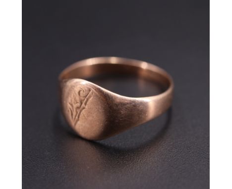 An antique 9 ct rose coloured yellow metal signet ring, its face foliate-engraved, Q, 2.4 g
