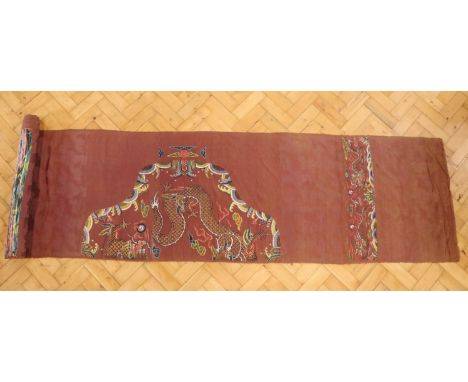 A roll of vintage Chinese fabric, silk-embroidered in patterns of dragons on a woven cloud pattern ground, early 20th Century