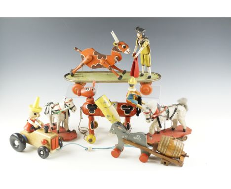 A group of vintage wood and tinplate pull-along toys, including a matador and bull bearing a label "La Norimberga Made in Ita