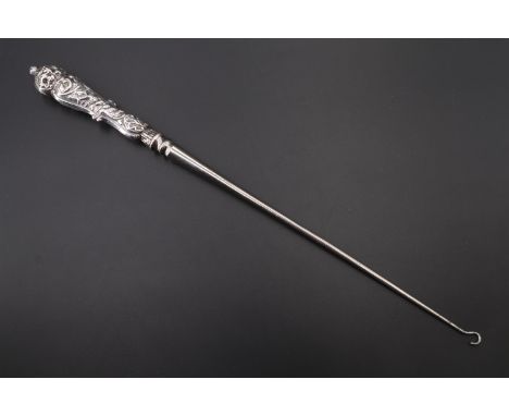 An uncommonly long late Victorian silver handled button hook, the handle embossed with flowers among scrolls, William Comyns 