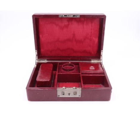 A George V claret leather jewellery box, the interior fitted with three compartments and a ring holder, the lid bearing an es