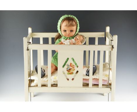 A vintage doll's cot together with two composition dolls, the larger having articulated joints and sleeping eyes, cot 51.5 x 