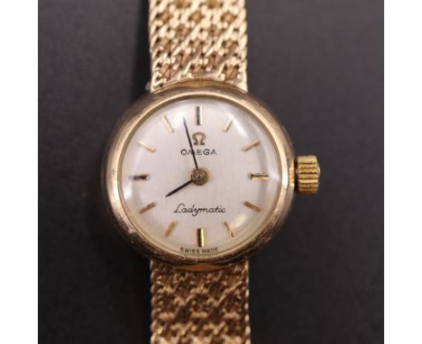 A 1960s Omega Ladymatic 9 ct gold wristlet watch, having a 24 jewel automatic movement, a silver dial with baton markers and 