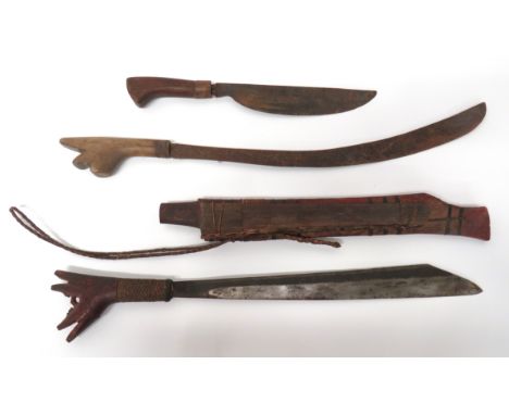 Two Malayan/Borneo Parang Short Swordconsisting 17 inch, single edged blade widening towards the point.  Carved wooden hilt w