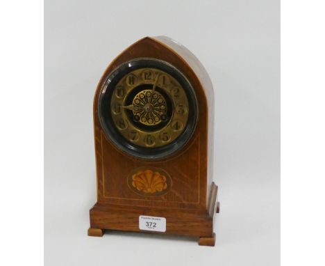 Early 20th century oak cased mantle clock, the arched top over a gilt metal chapter ring with Arabic numerals above an inlaid