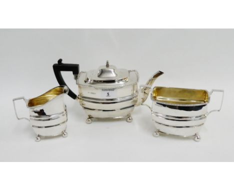 George V silver three piece teaset comprising teapot, sugar bowl a and cream jug, all on four bun feet, with makers marks H. 