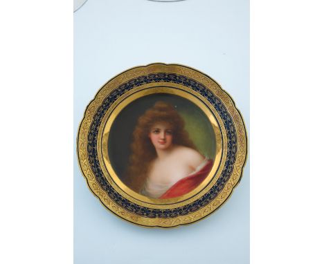 A late 19th Century Vienna cabinet plate, painted with a portrait of a semi-nude female with auburn hair, raised gilt border 