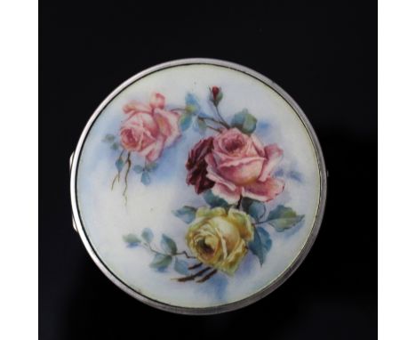 A George V silver and enamelled box, Adie Brothers, Birmingham 1928, circular form, champagne enamel painted with pink and ye