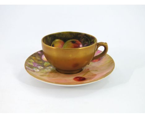 E Lockyer and F Harper for Royal Worcester a fruit painted cup and saucer, circa 1918, decorated with apples, grapes and cher