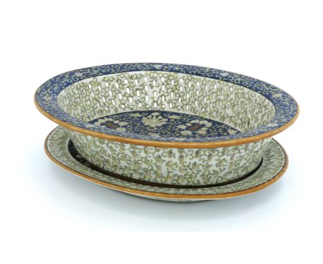 A Chinese reticulated oval basket on matching stand, blue enamel decoration of scrollwork, white foliage and character marks 