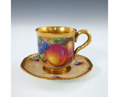 A Royal Worcester fruit painted cabinet cup and associated saucer, circa 1960, shaped relief moulded and gilded border, decor