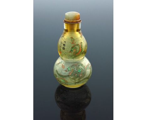 A Chinese double gourd clear glass snuff bottle, internally painted with dragons amongst clouds chasing flaming pearls, signe