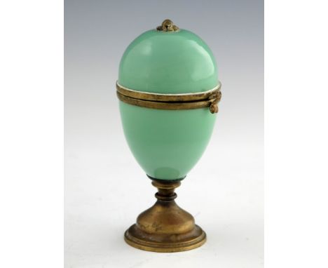 A French Palais Royale glass and gilt mounted pedestal egg box and scent bottle, the jade green box with hinged lid opening t