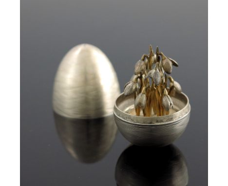 A Modernist silver novelty surprise egg, Peter Nicholas and Co., London 1988, textured engine turned wave design, opening to 