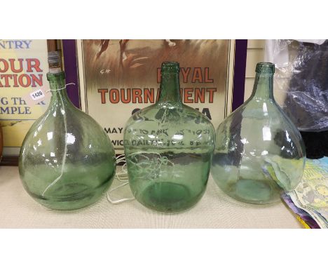 Three green glass carboys, one converted to a lamp - tallest 40cm