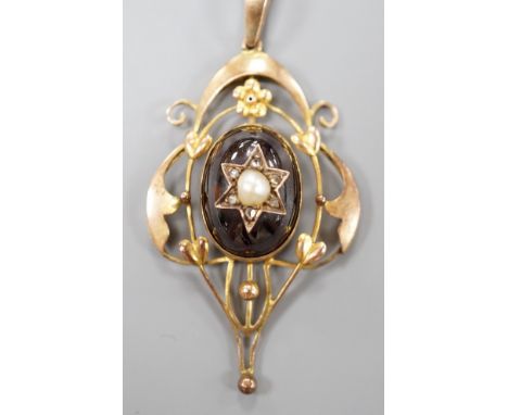 An Edwardian Art Nouveau 9ct, garnet, split pearl and diamond set pendant, overall 57mm, gross weight 6.8 grams.